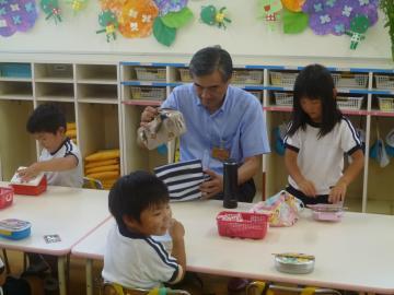 高宮幼稚園の昼食会でお弁当を袋から出している市長の写真