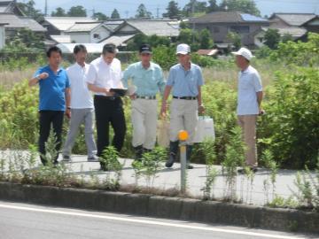 亀山学区連合自治会のみなさんから説明を受けながら現場を訪問する市長の写真