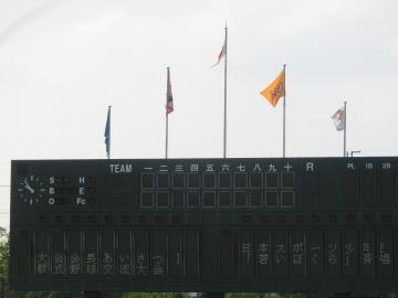 野球場会場にある国旗と大会旗掲揚の写真
