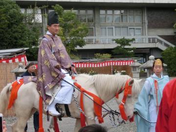 白馬に乗って武者行列に参加する市長の写真