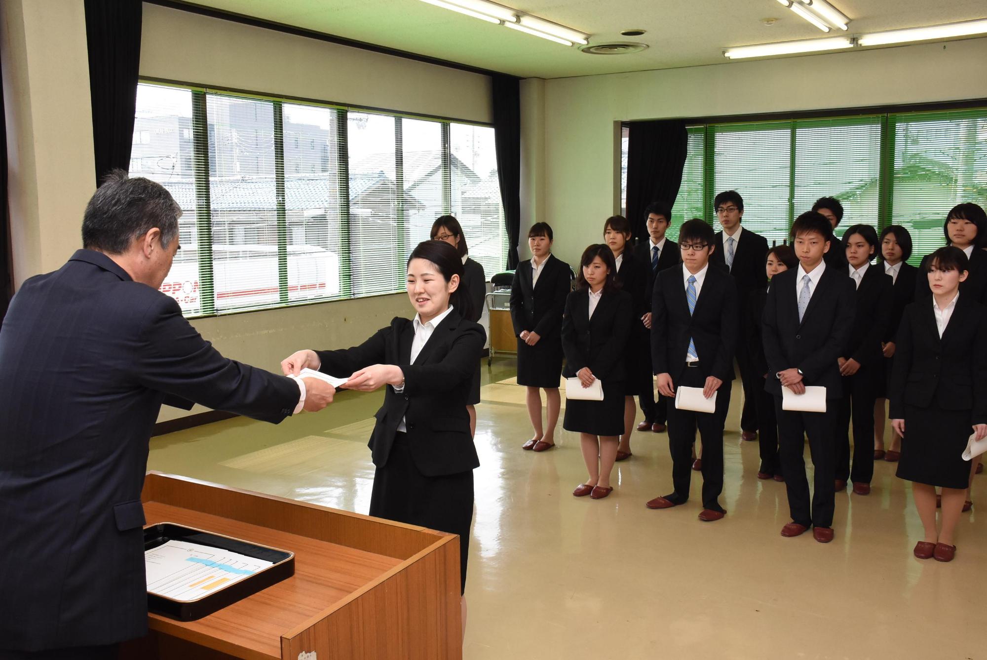 新規採用の市職員に辞令を交付している市長の写真