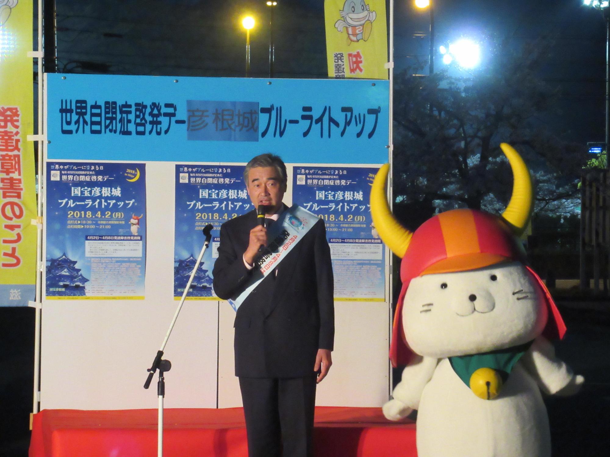 世界自閉症啓発デー2018滋賀県ブルーライトアップであいさつしている市長の写真