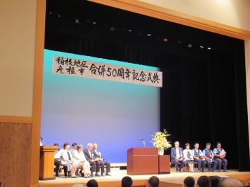 稲枝地区彦根市合併50周年記念式典舞台上で着席をしている来賓の方々の写真