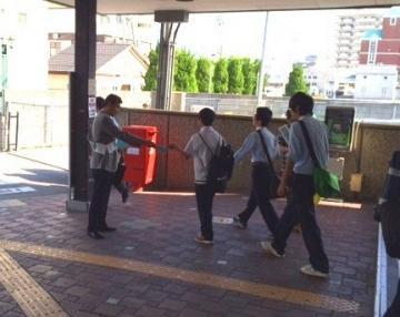 駅前で通行市民に街頭啓発を行っている様子の写真