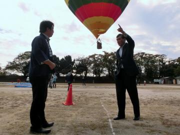 気球が上がっている前で手を上げている市長の写真
