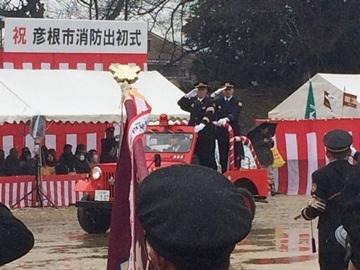 赤い車に乗って敬礼のポーズをしている消防隊員の謝意sン