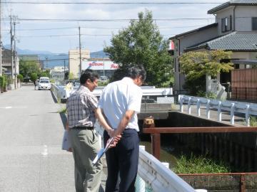 現地調査で川をのぞき込む市長の写真