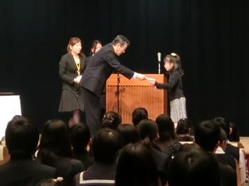 小さな女の子に表彰状を授与している写真