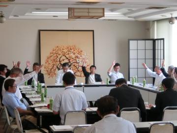 びわ湖・近江路観光圏協議会で参加者達が挙手をしている写真