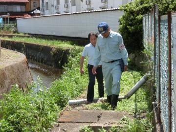 川岸を歩いて調査している市長の写真