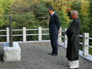 天應寺の石碑を見ている市長の写真