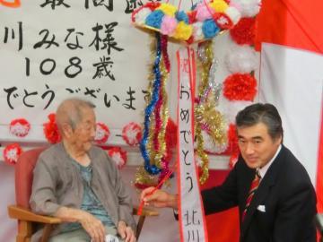 県内最高齢者の北川さんを敬老訪問している市長の写真