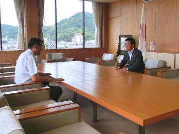 市長室で知事と向かい合って座り話をしている写真