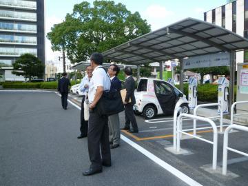 市内で貸出のある電気自動車をバックに写る市長の写真