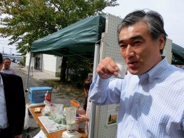 紙コップで野菜ジュースを飲んでいる市長の写真