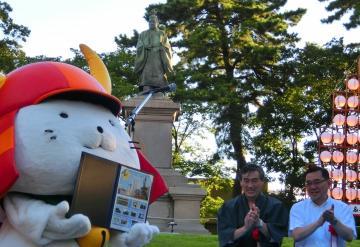 井伊大老の銅像とひこにゃんと拍手をしている市長の写真