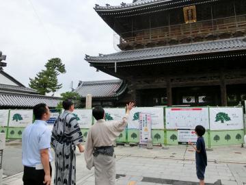 浴衣を着た彦根市長が同じく浴衣を着た長浜市長に大通寺を案内していただいている写真