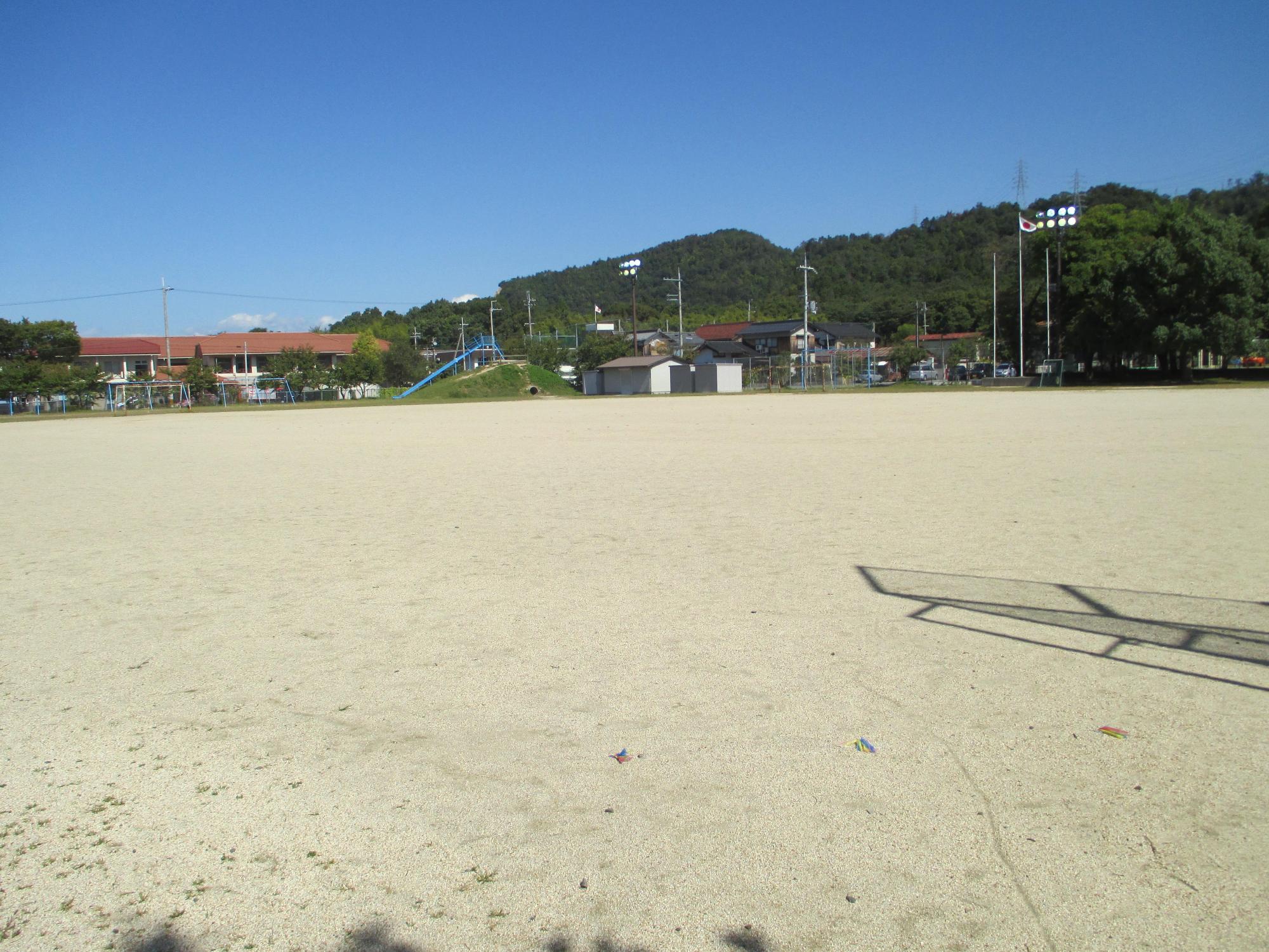 青空と鳥居本小学校の校舎と運動場の写真