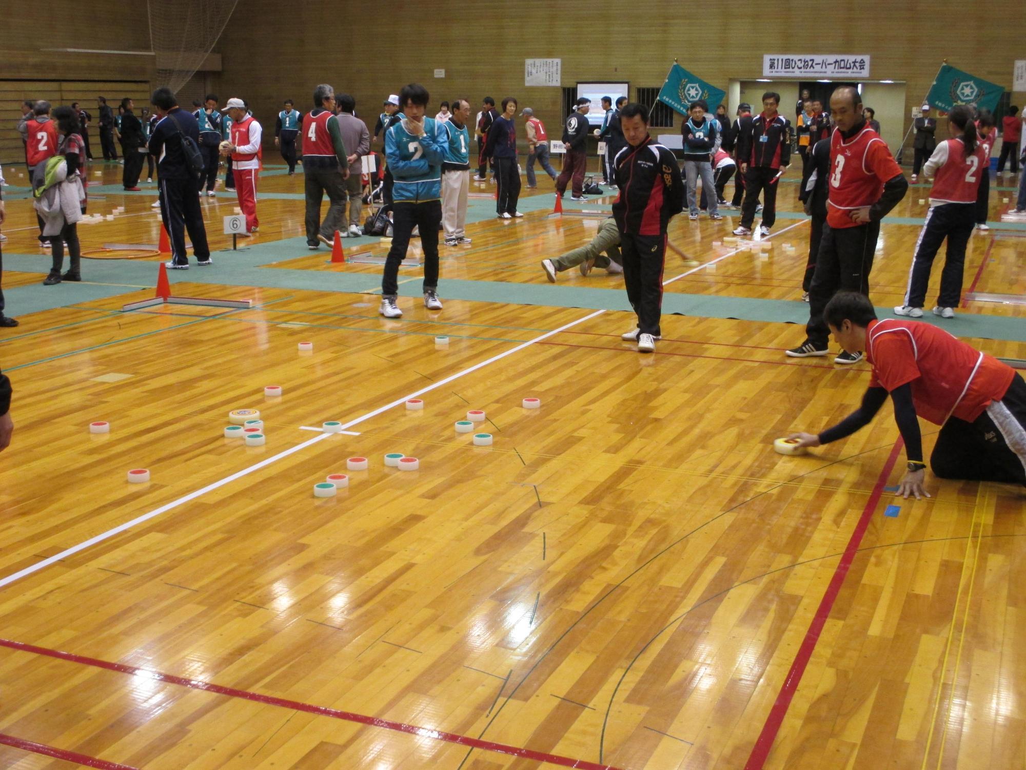 大会の様子、相手の駒を狙って投げようとしている写真