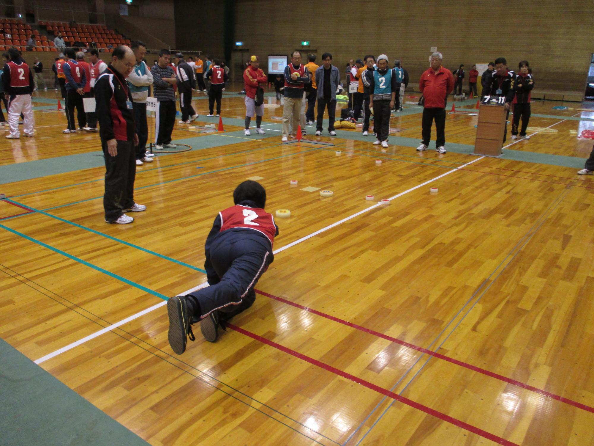 相手の駒をめがけて投げている参加者の写真