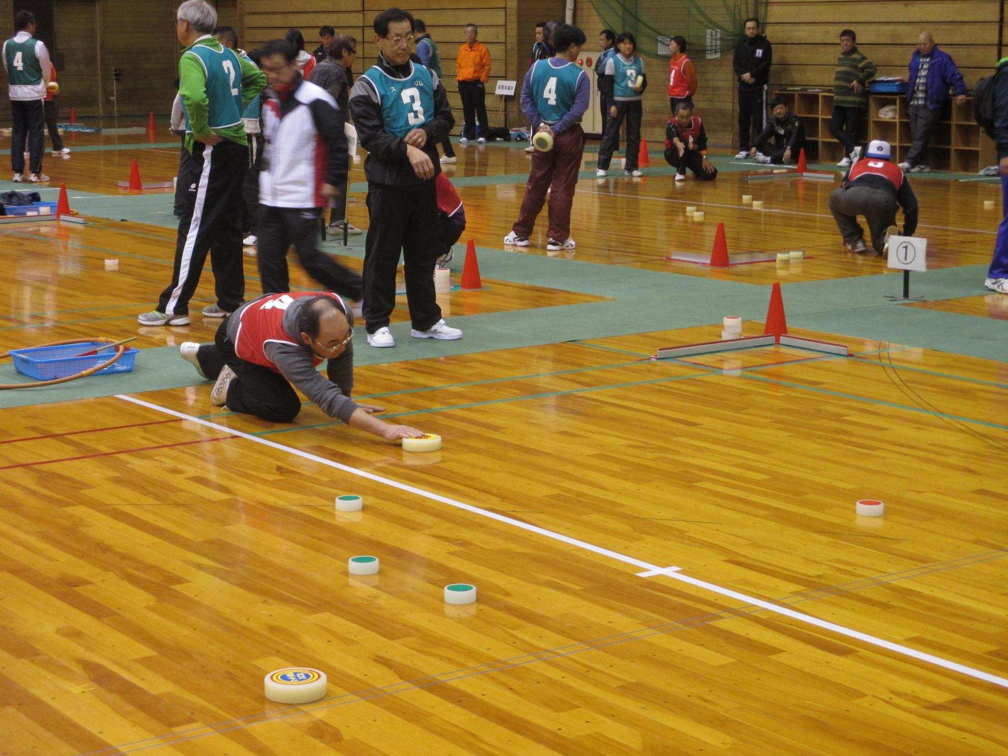 相手の的をめがけて駒を投げようとしている写真