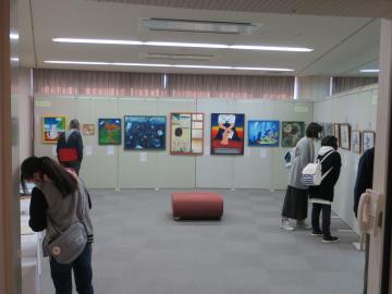 研修室で絵画作品を見学している来場者の写真