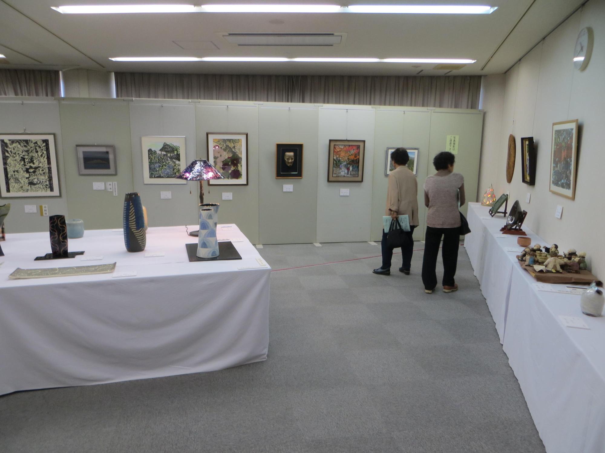 美術工芸品が並べられた会場内の写真