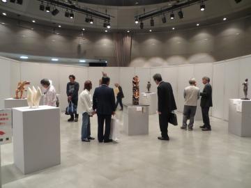 彫刻部門の展示作品を見学している来場者の写真