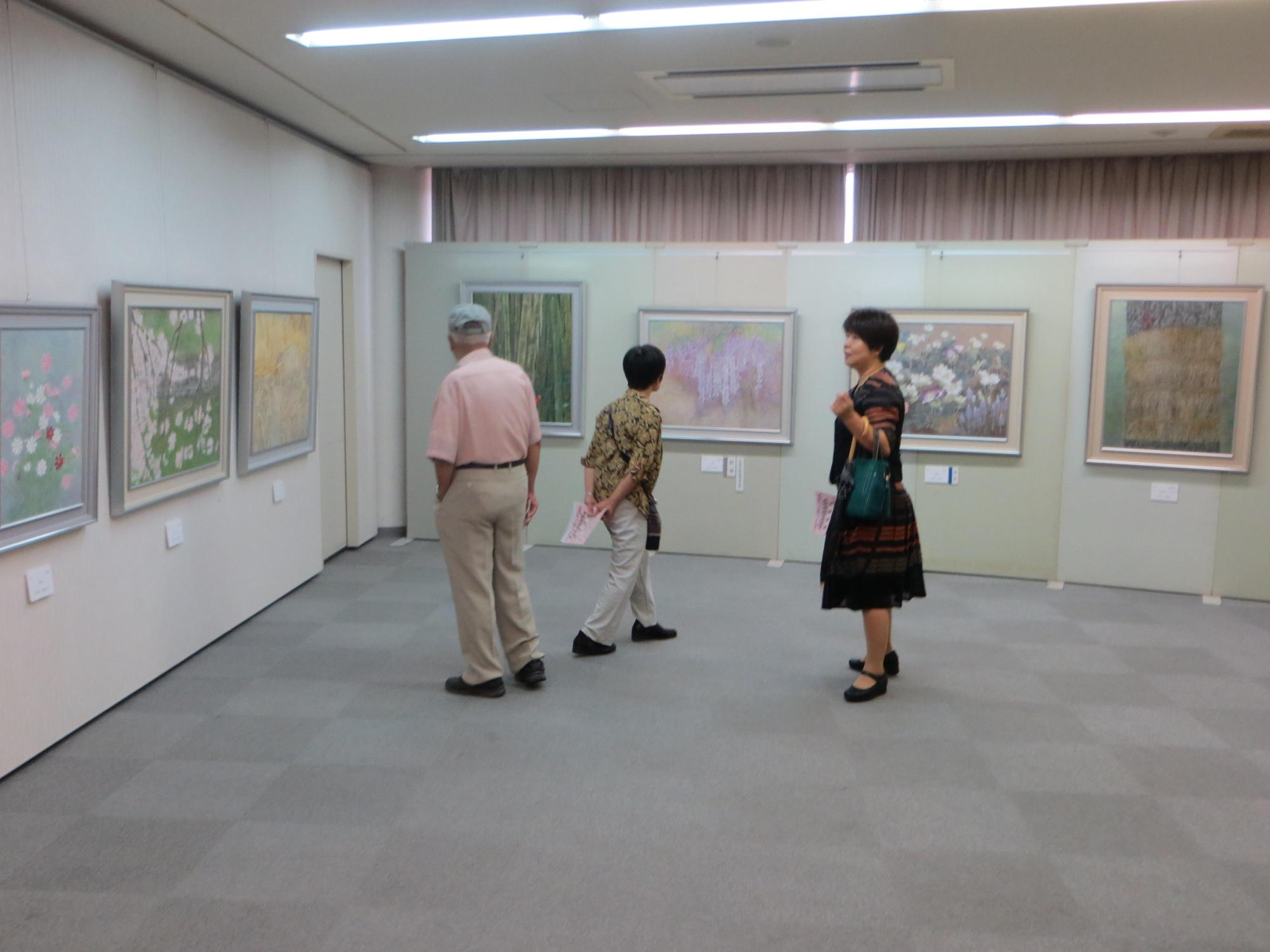 日本画部門の展示作品を見学している来場者の写真