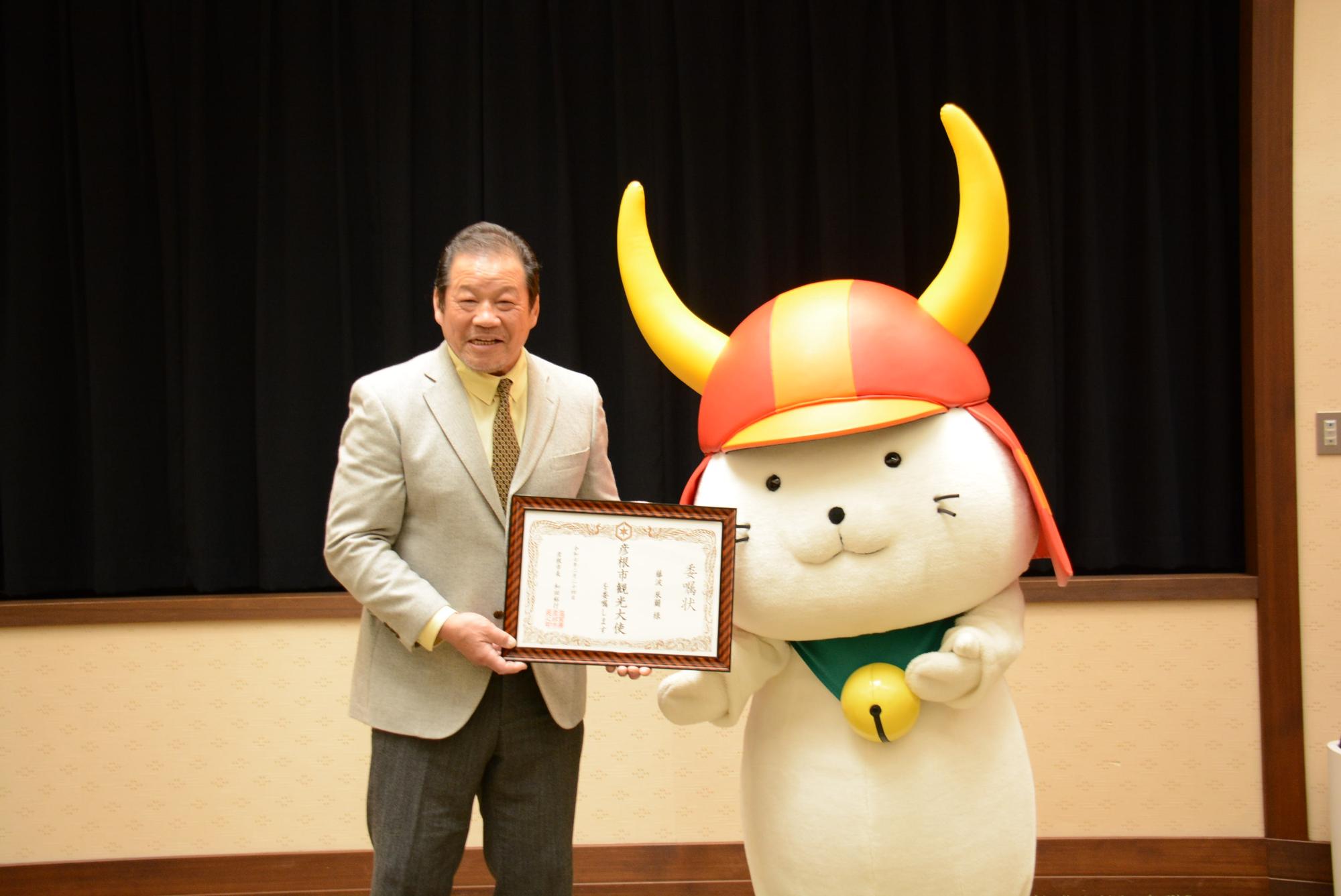 藤波さんとひこにゃんが委嘱状をもっている写真