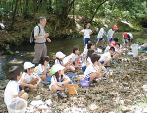 矢倉川で会長から説明を聞く子供たちの写真