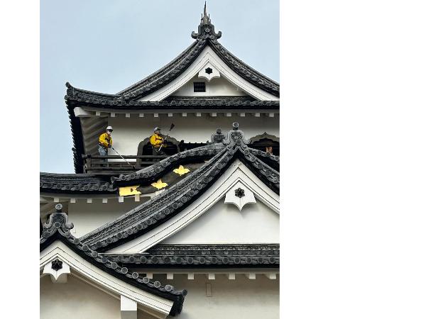 天守の外側のすすはらいをしている様子