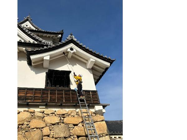 破風の裏のすす払いをしている様子