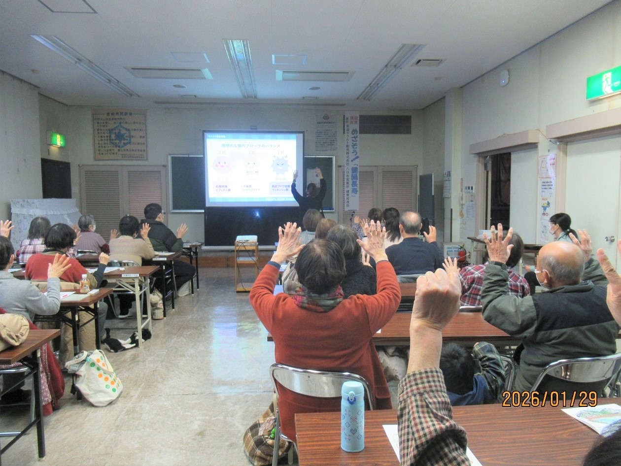 講座中参加者が座ったまま簡単な体操をする様子