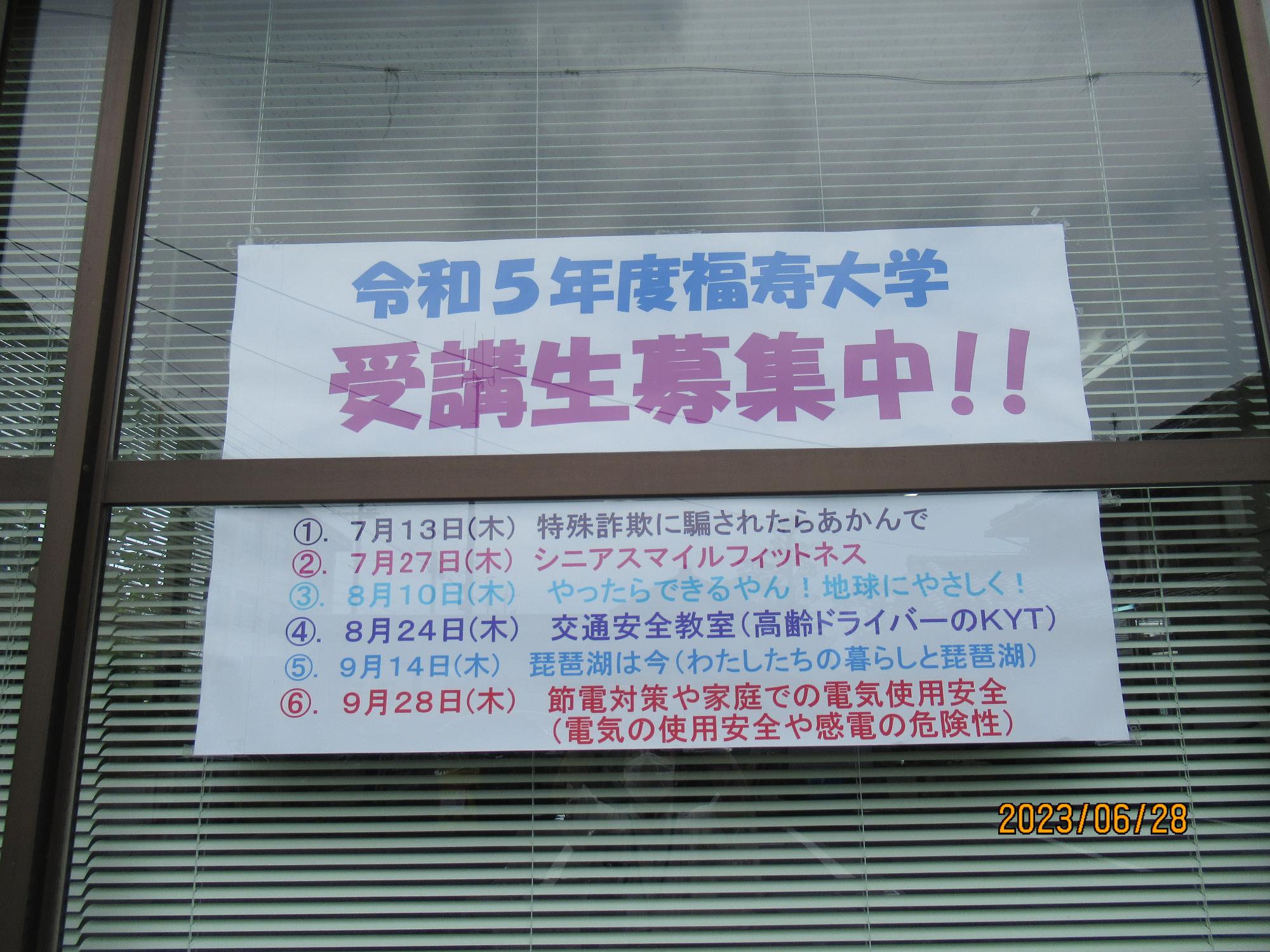 窓に貼られた「令和5年度福寿大学受講生募集中」記載の紙の写真