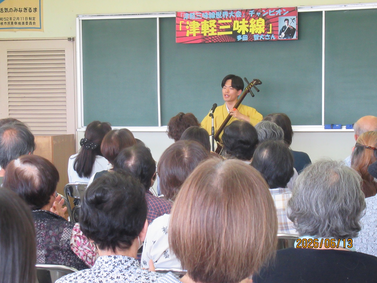 津軽三味線を演奏する男性と観客