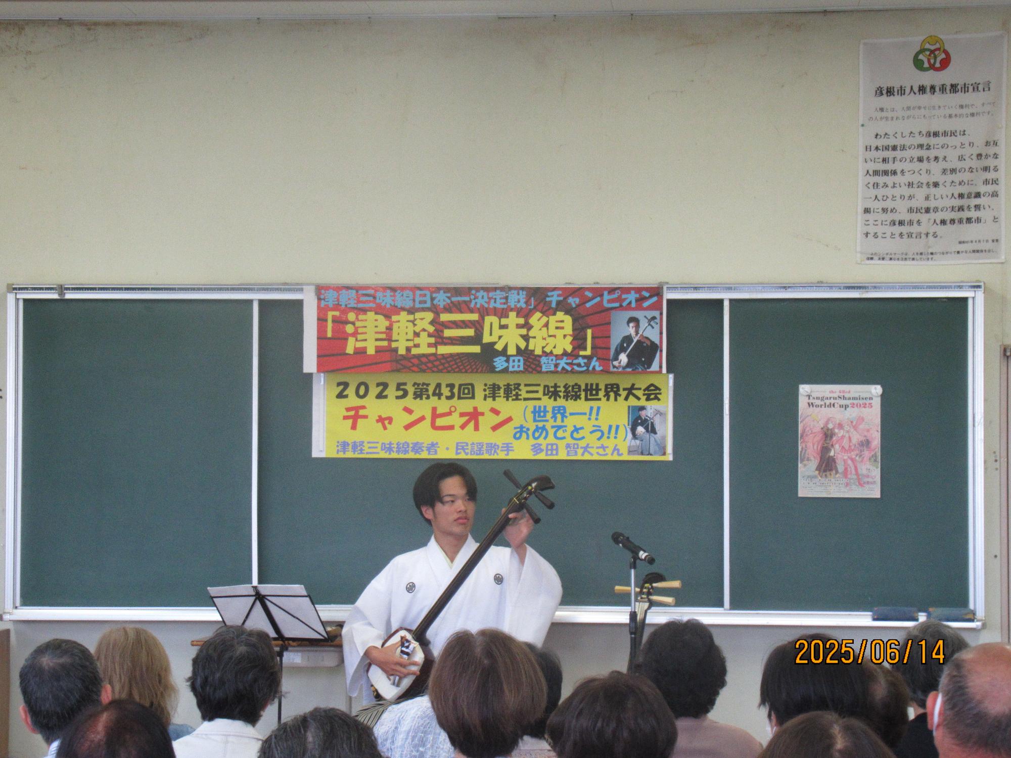 男性が津軽三味線を演奏している写真