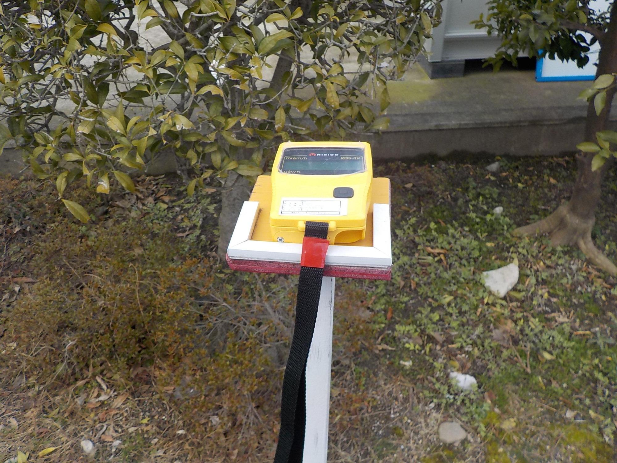 野外に置いてある黄色い放射線量の測定器の写真