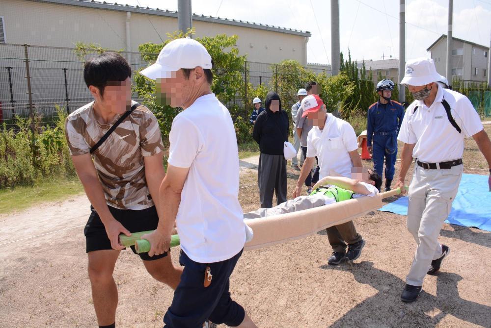 応急担架搬送を体験する様子