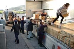 支援物資をトラックに運んでいる人々の写真