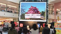 スクリーンの前でまるばつゲームを楽しむ親子連れの画像