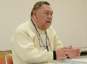 椅子に座って話している男性の写真