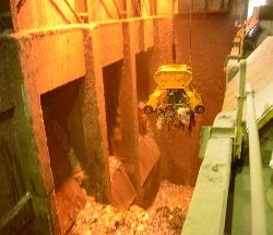 大きなクレーンが燃えるごみをつかんでいる様子の写真