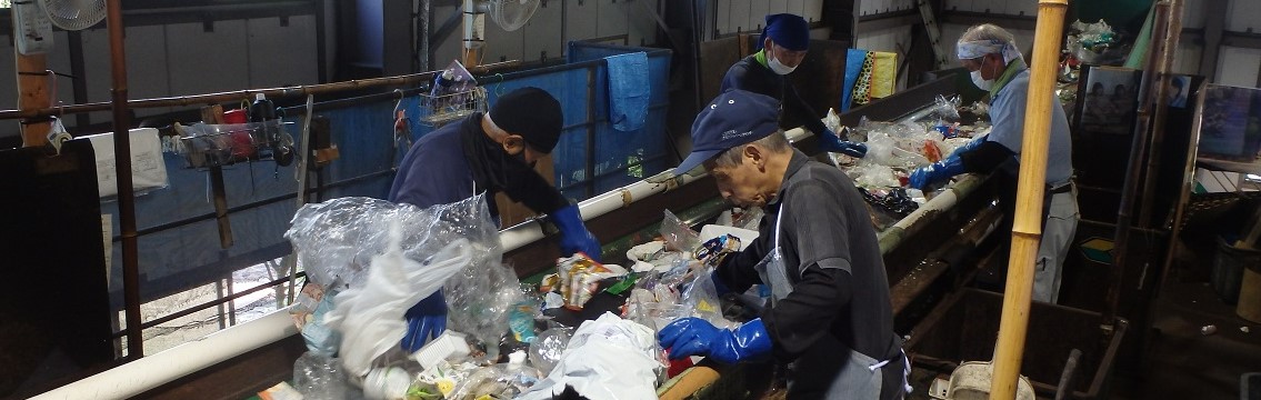 作業員がラインでごみの選別をしている様子の写真