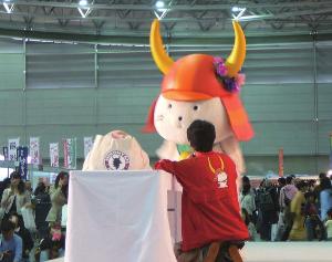 花飾りをつけて壇上に立つひこにゃん