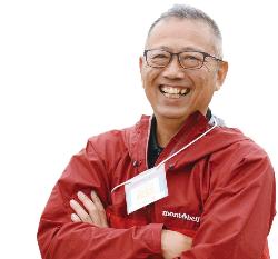 腕を組んだ笑顔の男性の近影