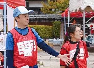 ボランティアの服を着た男性と女性の写真