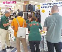 商業施設に設置されたブースで啓発を行う会員たちの様子の写真