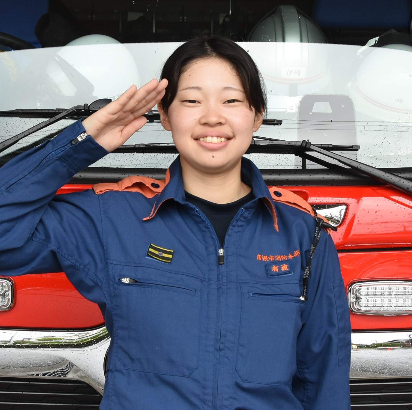 消防車の前で敬礼のポーズをとる有波さん