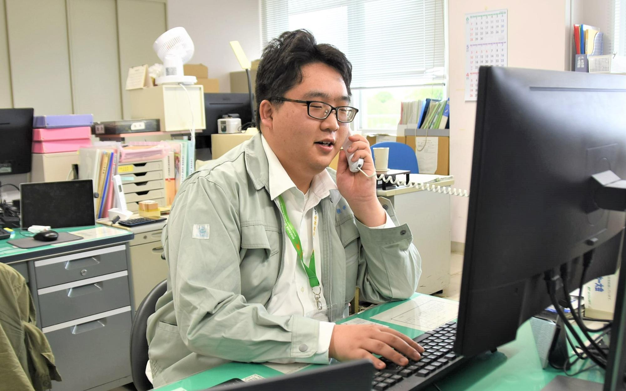 パソコン作業をしながら電話対応をする林さんの様子